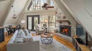 A spacious loft with a high ceiling, a fireplace, a dining area, and a cozy seating area. - Chalet on Ski Mountain - Stunning Views of Mount LeConte - Right in Gatlinburg! (Gatlinburg)