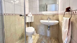 A bathroom with a toilet, sink, and glass shower enclosure. - Apartman Kate 1 (Dramalj)