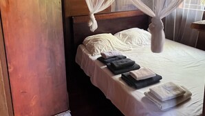 Una stanza con un letto, un armadio in legno e una finestra vista.