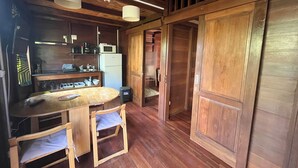 Una cucina funzionale con mobili in legno, un forno a microonde e un lavandino. C'è un piccolo spazio pranzo con tavolo e sedie.