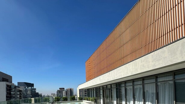 A modern hotel with a long swimming pool, a wooden facade, and a clear blue sky. - TrevizZo HCOR (Sao Paulo)