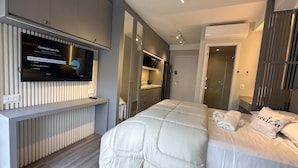 A modern hotel room with a large bed, a TV mounted on a wall, and a wardrobe with sliding doors. - TrevizZo HCOR (Sao Paulo)