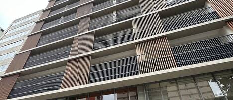 A modern high-rise building with multiple balconies and large windows.