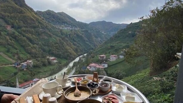 Una mesa con diversos platos y una vista panorámica de un valle.