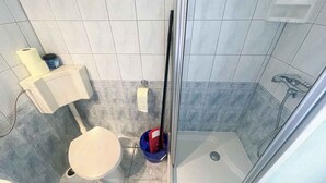 A small bathroom with a toilet, a shower, and a sink. - Apartman Kate 2 (Dramalj)