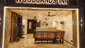 L’intérieur du Woodlands Inn se distingue par son comptoir d’accueil, ses meubles en bois et une maquette de navire accrochée au mur.
