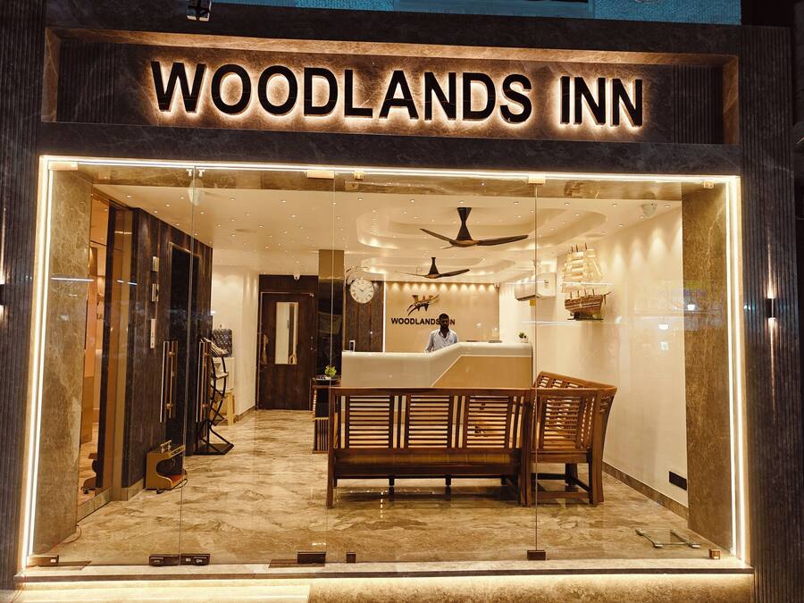 The interior of the Woodlands Inn, featuring a reception desk, wooden furniture, and a ship model on the wall.