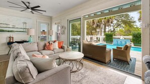 A spacious living room with a large sofa, round coffee table, and wicker chairs. A ceiling fan and large windows provide natural light. - 6-Seater LSV & Bikes Included! Private Pool, 2 Kings, Pet Friendly! Seagrove Eastern Lake! (Santa Rosa Beach)