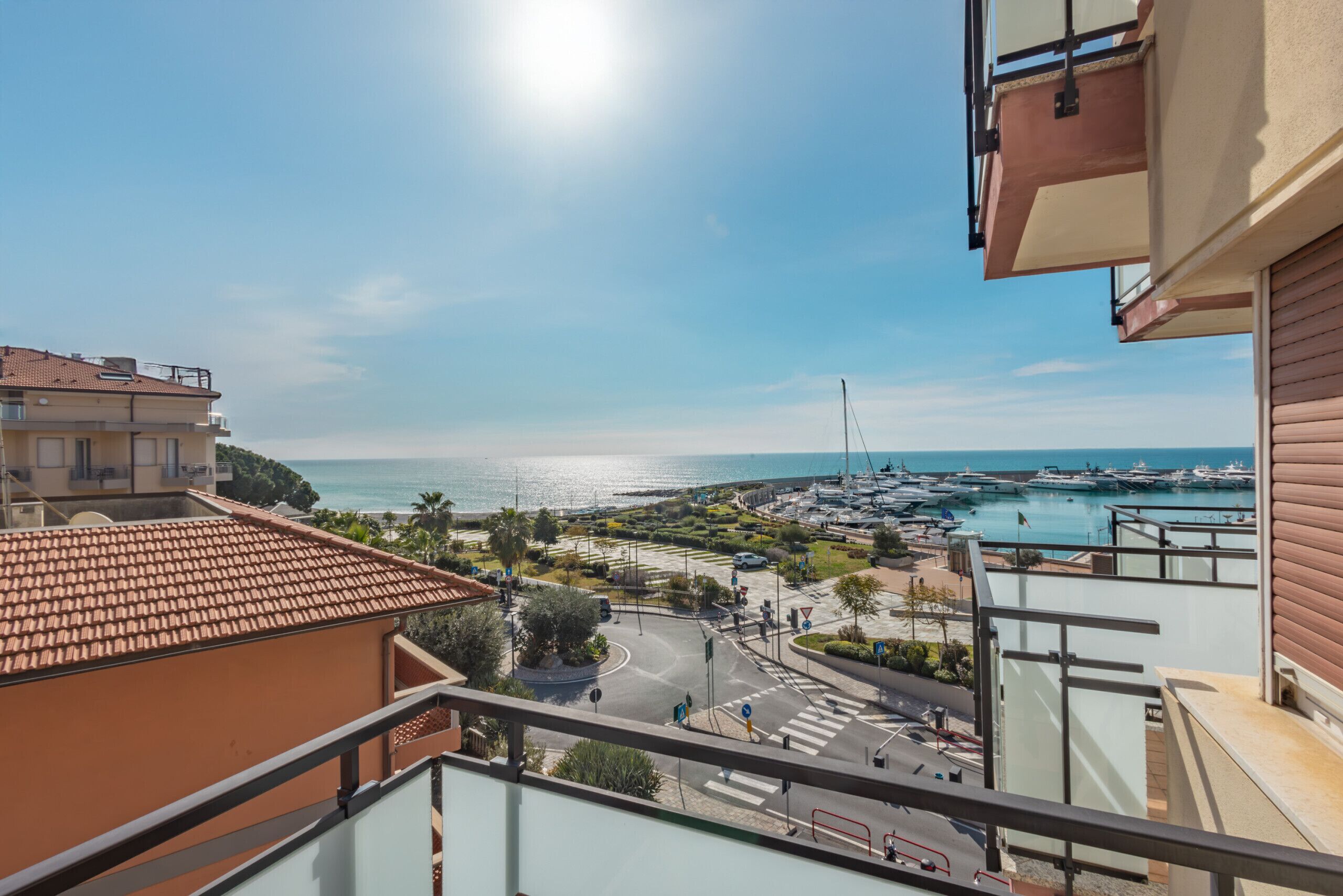 Ein Balkon mit Blick auf einen Yachthafen und das Meer.