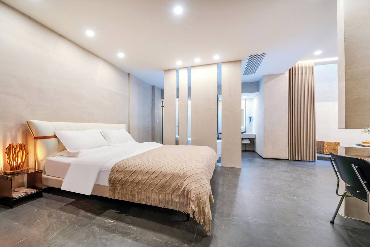 Ein modernes Hotelzimmer mit einem großen Bett, einem Schreibtisch und einem Sessel.