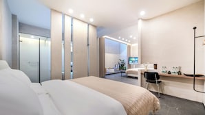 A modern hotel room with a large bed, a desk with a chair, a TV, and a bathroom with a glass shower. - Xiyou Hotel XIan City Wall Branch (Xi'an)