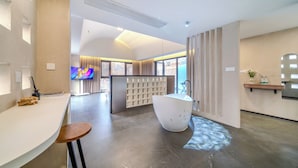 Un bagno moderno con una vasca freestanding, un mobile lavabo con specchio e un'ampia finestra che offre luce naturale.