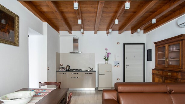 Un espacio habitable compacto con comedor, kitchenette y zona de estar.