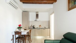 Een kleine keuken met een eethoek, een bank en een houten plafond.