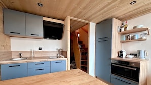 Une cuisine moderne avec des armoires bleues, un plan de travail en bois et un four encastré.