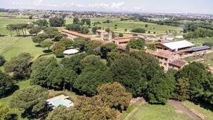 An aerial view of a property with a swimming pool, multiple buildings, and surrounding greenery. - Tenuta Pantano Borghese - Apartment 14 (Monte Compatri)