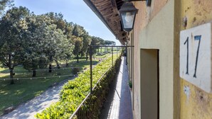 A balcony with a view of a garden and trees.