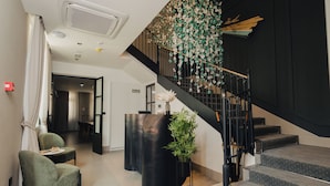 A modern lobby with a staircase, a reception desk, and a seating area. - Hotel Flaneur (Belgrade)