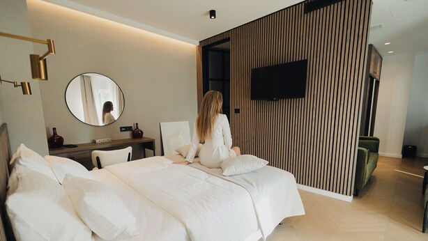 A modern hotel room with a large bed, a desk, and a television on the wall. - Hotel Flaneur (Belgrade)