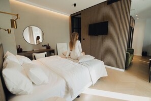 A modern hotel room with a large bed, a desk, and a television on the wall. - Hotel Flaneur (Belgrade)