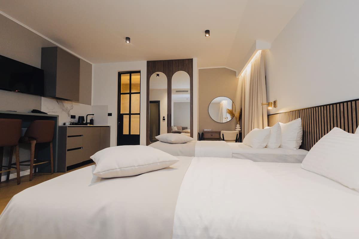 Une chambre d’hôtel comprenant un lit, un bureau avec une chaise, un miroir et une armoire.