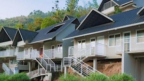 A row of modern, multi-story buildings with balconies and external staircases. - Rains Valley Resort By Teal Luxury Stays (Devikolam)