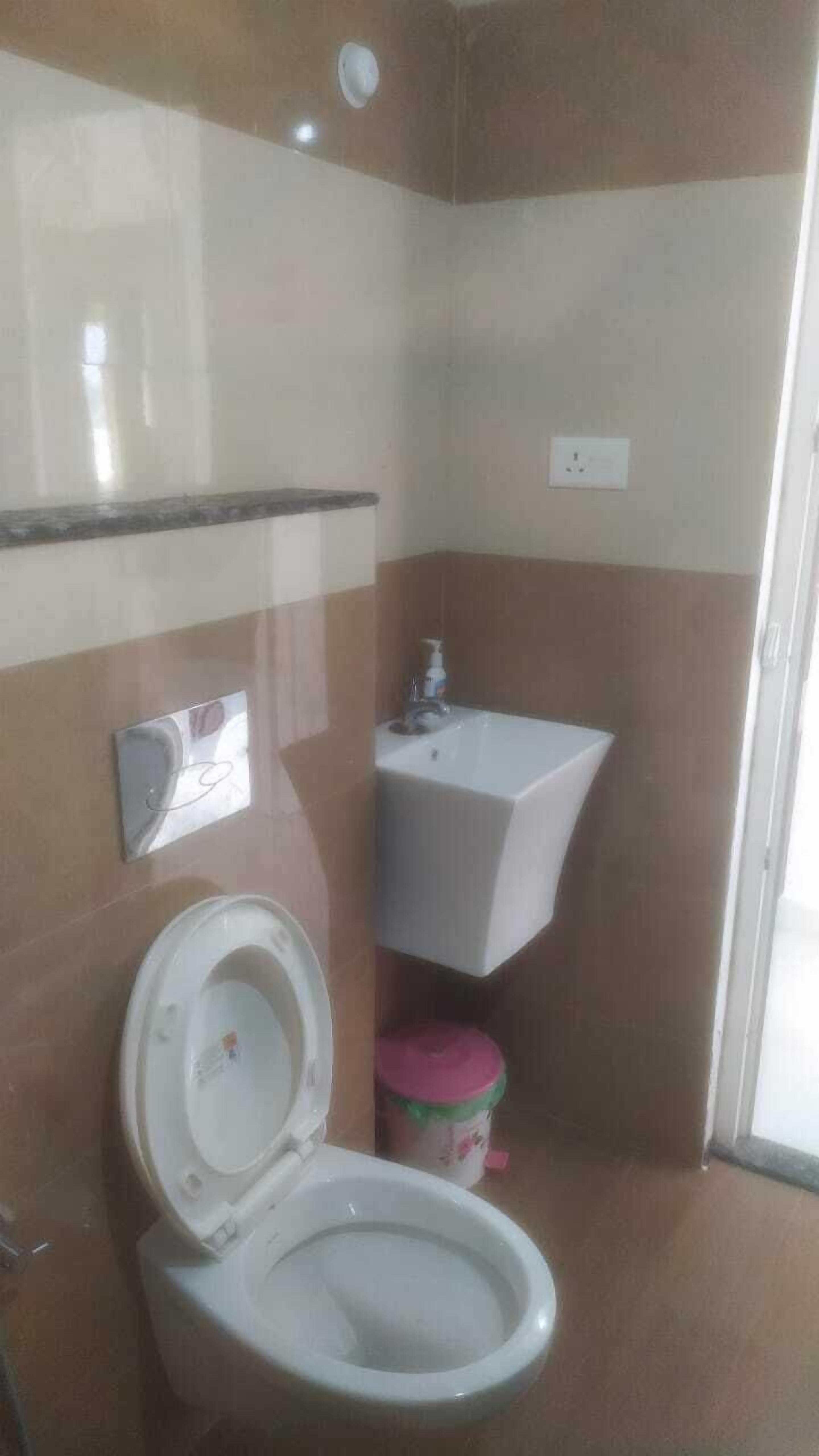 A bathroom with a toilet, a sink, and a mirror.