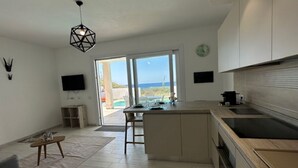 Una cucina moderna con una grande isola, un'area pranzo e vista sull'esterno.