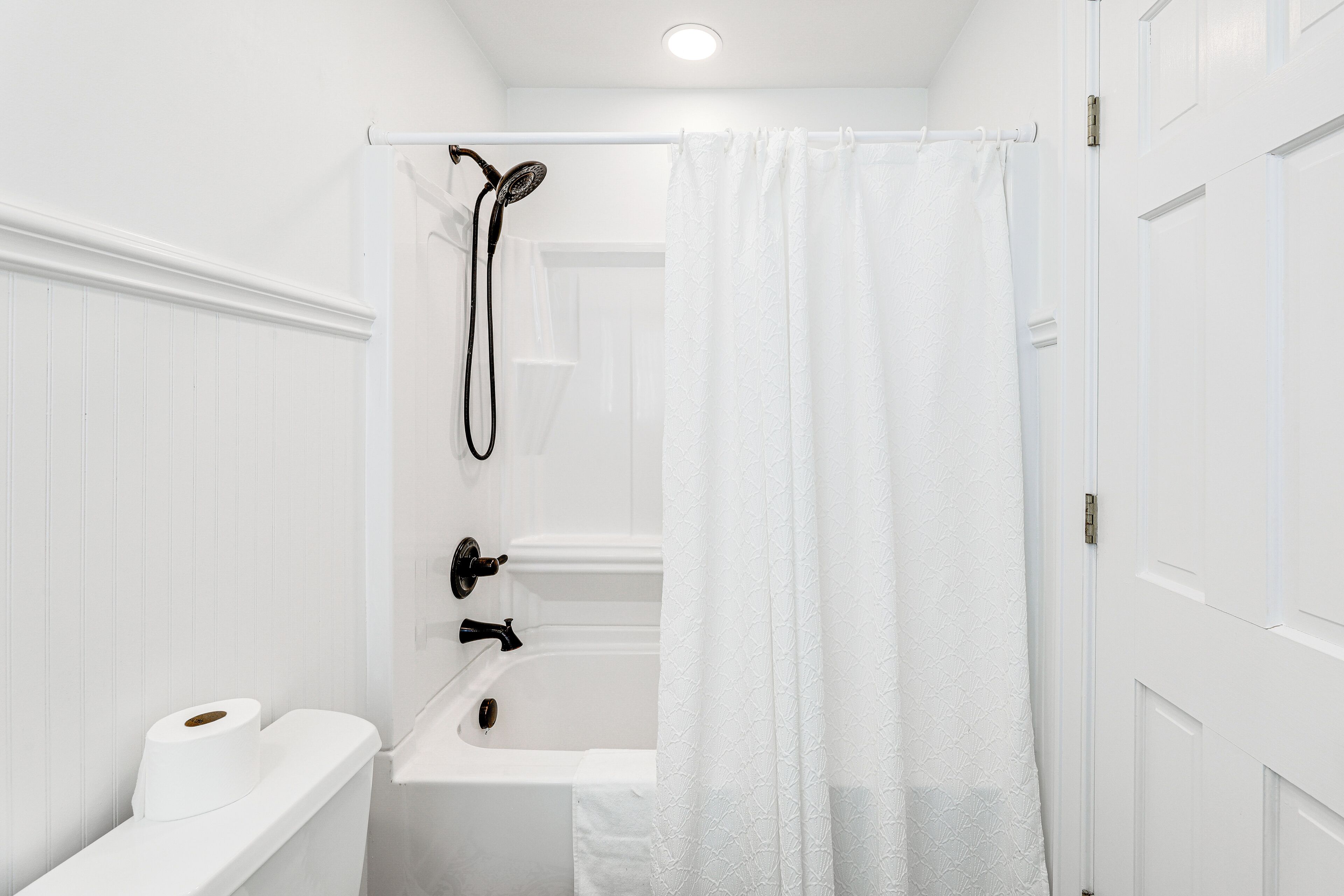 A bathroom with a shower, toilet, and sink.