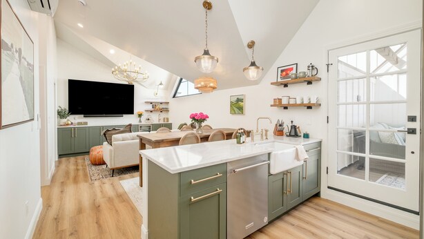 A modern kitchen with a central island, built-in appliances, and pendant lighting. - Luxe Designer Flat on Sloans Lake w/ Rooftop Deck (Denver)