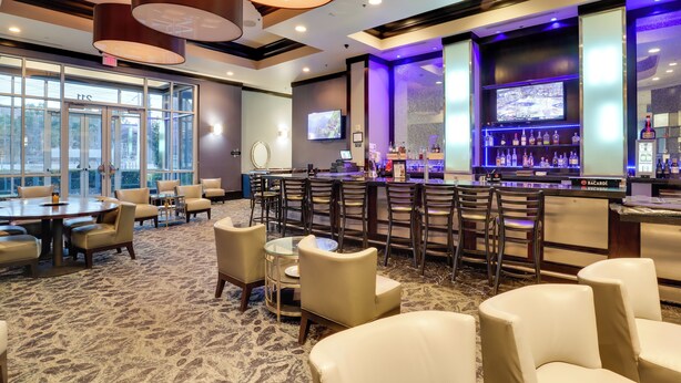 A hotel lobby with a bar area, seating arrangements, and a large window providing a view outside. - Sphere View, Near Dining & Nightlife: Luxe Condo (Las Vegas)