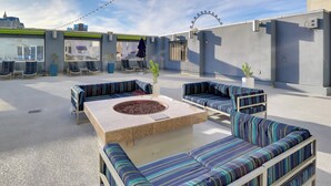A rooftop terrace with a fire pit, seating area, and large windows offering city views. - Sphere View, Near Dining & Nightlife: Luxe Condo (Las Vegas)