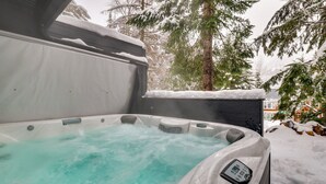 A hot tub with a control panel, surrounded by snow-covered ground and trees. - Hot Tub & Sauna: Mountain Living at Hyak Cabin! (Snoqualmie Pass)