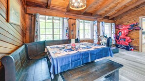 A wooden interior with a long table covered in a blue tablecloth, wooden benches, and a red dragon decoration. - 9 Mi to Spanaway Park: Home w/ Indoor Hot Tub (Spanaway)