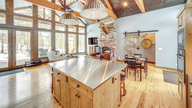 Un'ampia cucina con un'isola grande, travi in legno e un camino in pietra.
