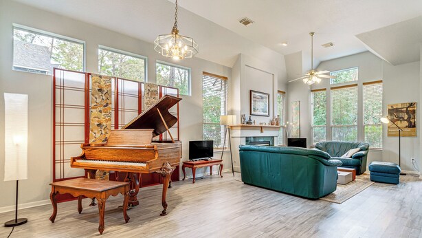 A spacious living room with a grand piano, a comfortable sofa, and a television. - Hot Tub, Fire Pit: Retreat in The Woodlands! (The Woodlands)