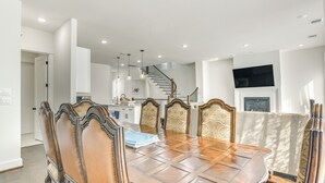 A dining area with a large wooden table, ornate chairs, and a staircase leading to an upper level. - 7 Mi to The Galleria: Modern Home w/ Fenced Yard (Houston)