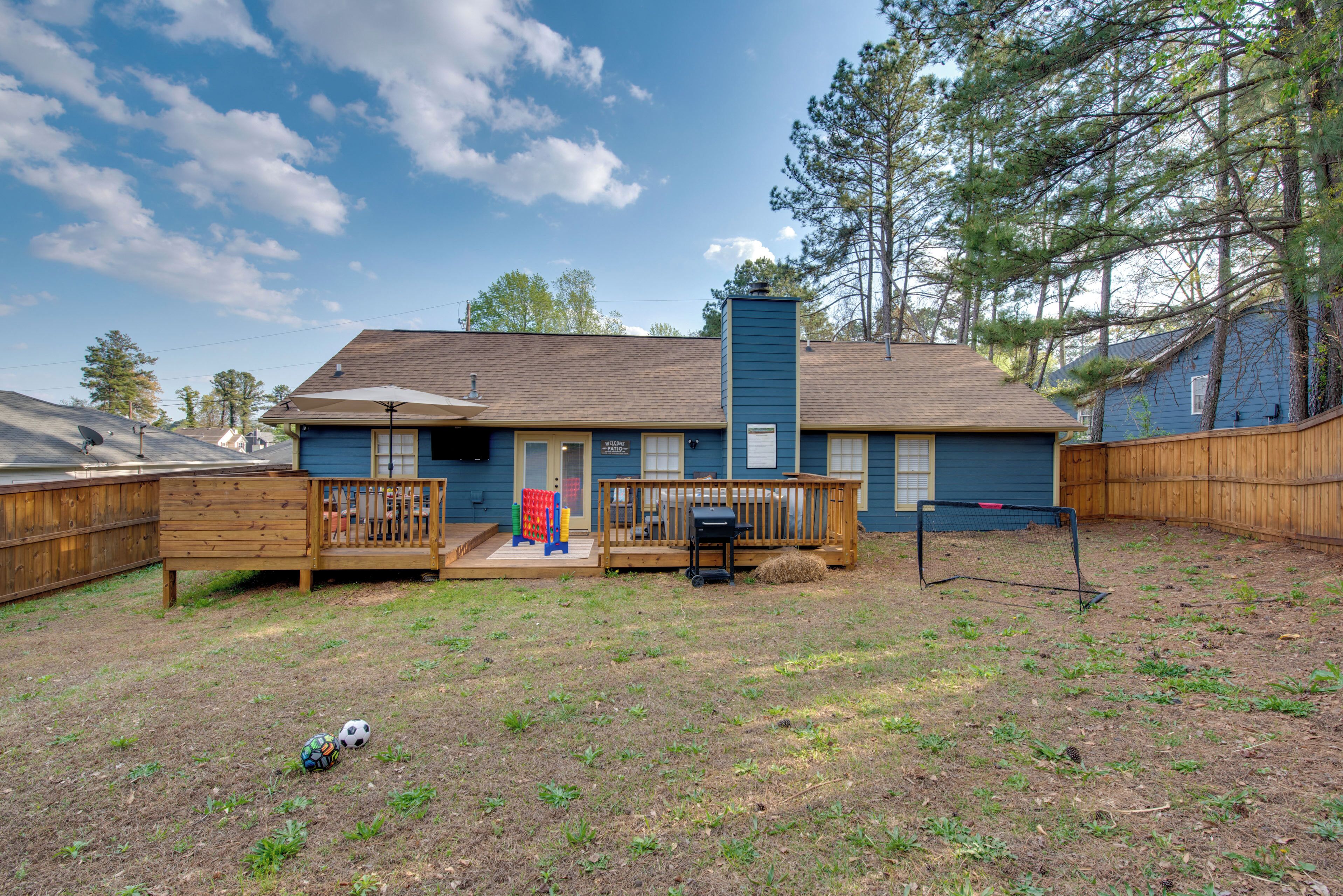 A two-story house with a fenced backyard, a front porch, and a chimney.