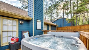 A hot tub on a deck with a wooden fence, a wicker basket with bottles, and a window with blinds. - 4 Mi to Airport: Atlanta Home w/ Deck & Hot Tub (Atlanta)