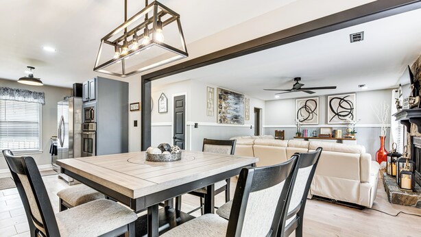 A modern kitchen with a dining area, featuring a wooden table and chairs, a built-in oven, and a refrigerator. - 4 Mi to Airport: Atlanta Home w/ Deck & Hot Tub (Atlanta)