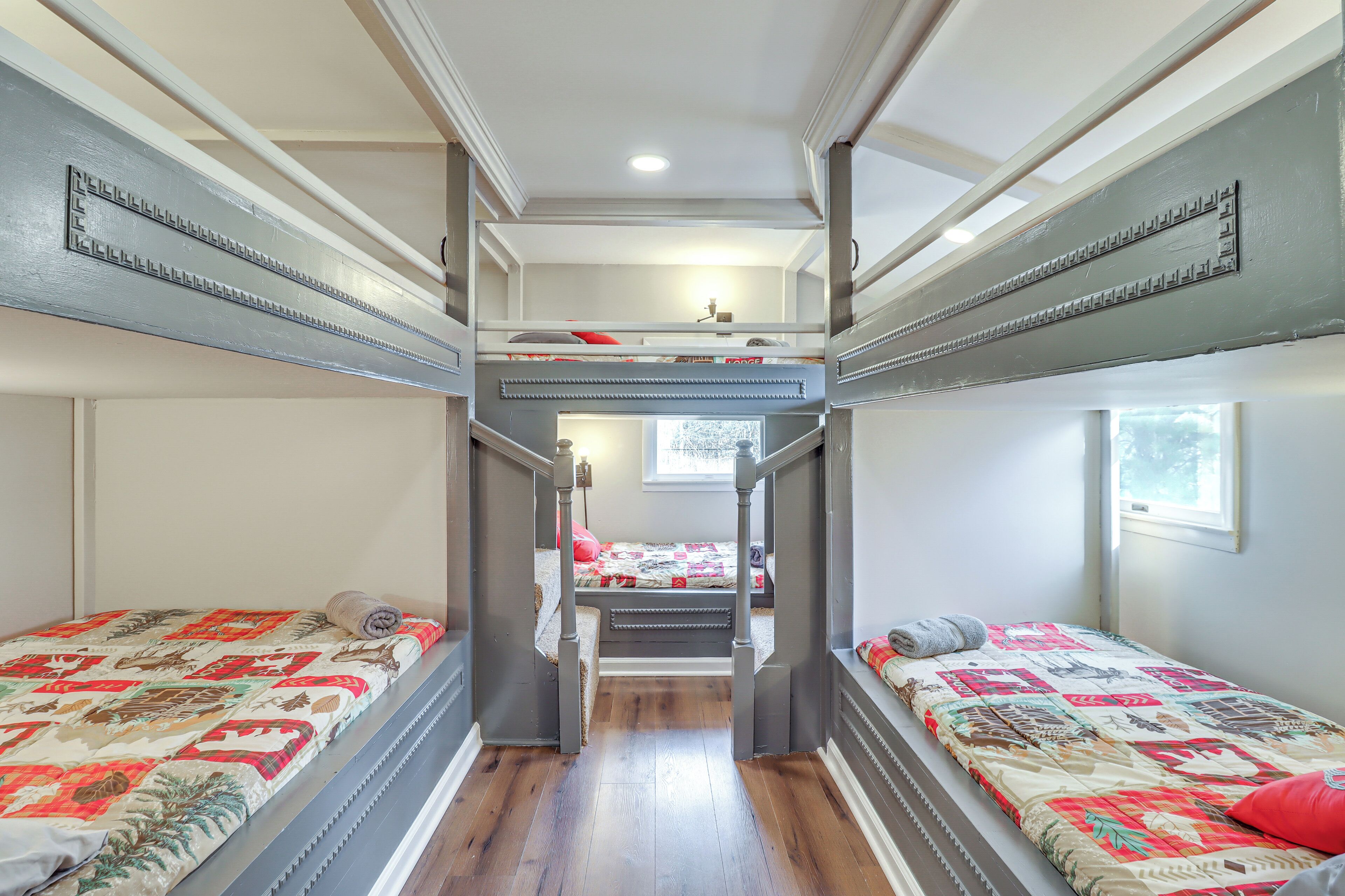 A room with bunk beds, a window, and a door.