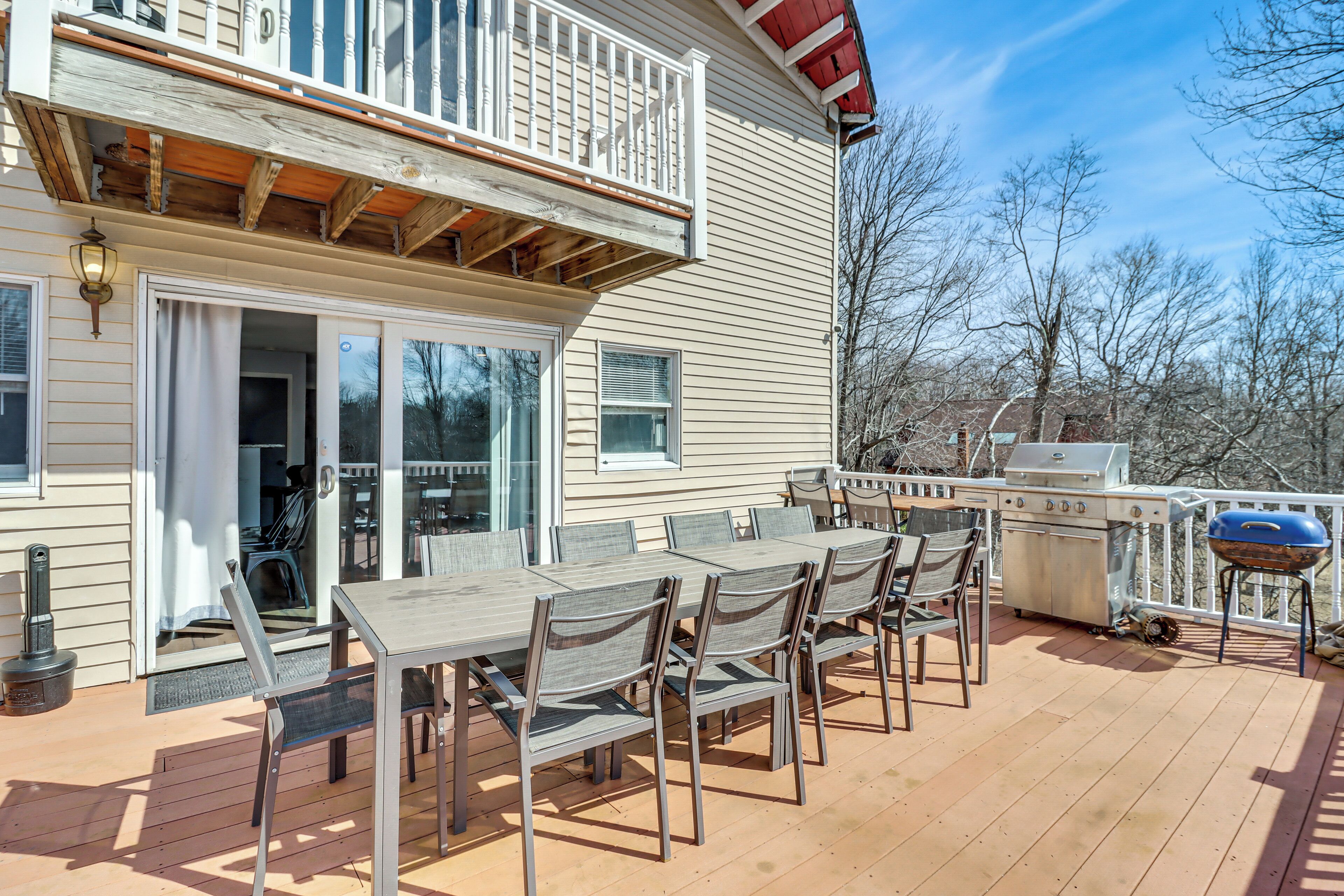 A deck with a table and chairs, a grill, and a covered area with a railing.