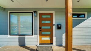 A front door with a window above it, a mailbox, and a wooden post.
