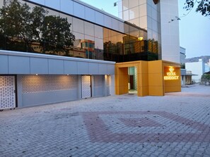 A modern building with a glass facade and a yellow entrance labeled "Veera Residency." - Veera Residency (Gingee)