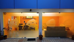 A hotel entrance with a reception desk, chairs, and a sofa. - Veera Residency (Gingee)