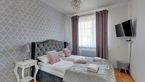 Een moderne slaapkamer met een groot bed, een nachtkastje, een televisie en uitzicht op het omliggende landschap.