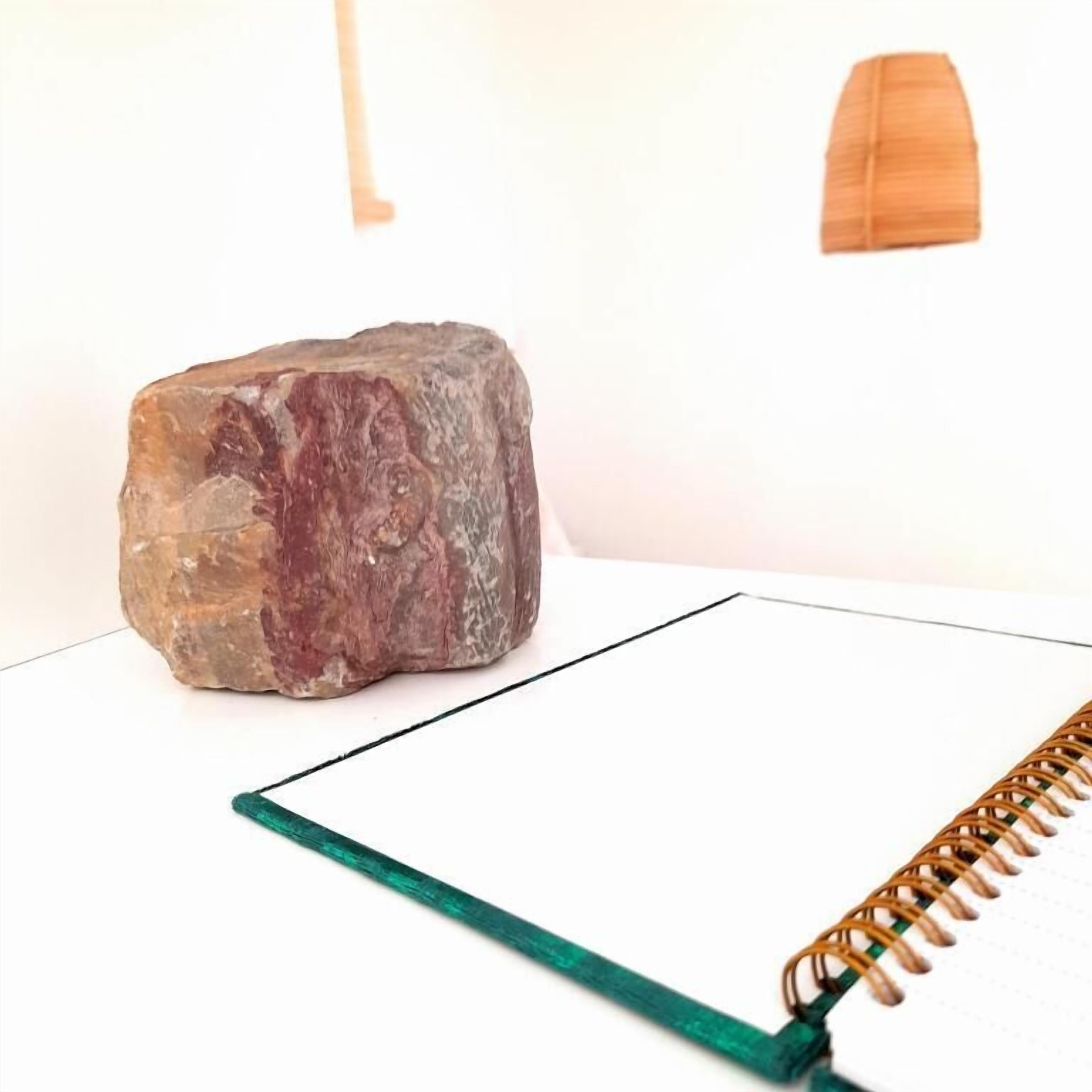 A notebook with a spiral binding on a white surface.