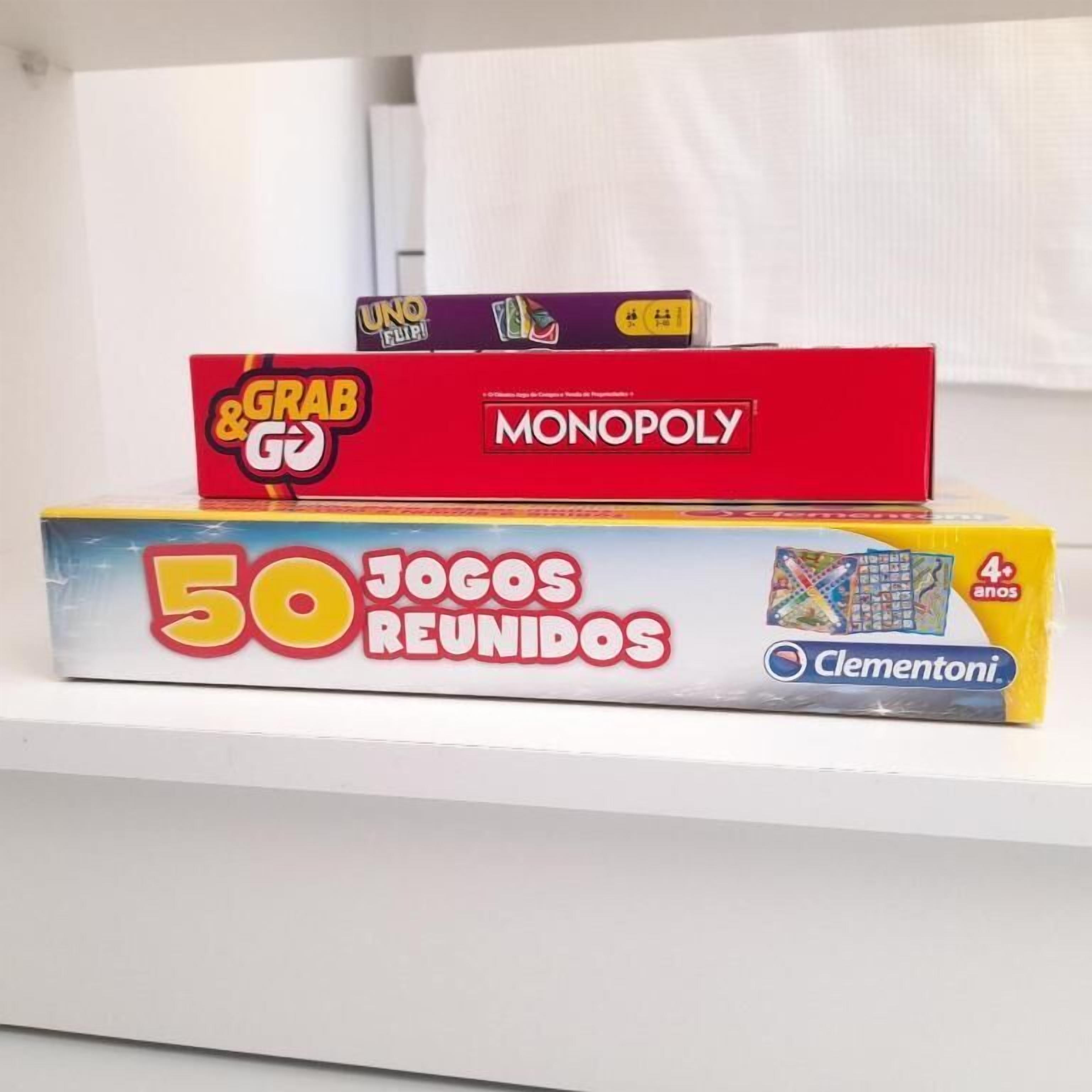 Tre brädspel på en hylla: UNO, Monopol och 50 JOGOS REUNIDOS.