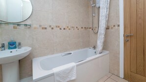 A bathroom with a bathtub, a sink, and a shower. - 1 Bedroom Twin Apartment (Newcastle-upon-Tyne)