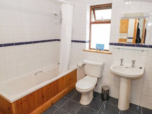 Ein Badezimmer mit Badewanne, Toilette und Waschbecken.